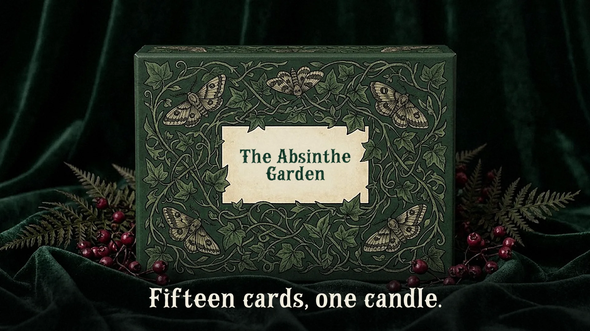 A green tarot card box patterned with vines and moths, its cream label printed The Absinthe Garden in Campflare, with the caption Fifteen cards, one candle.