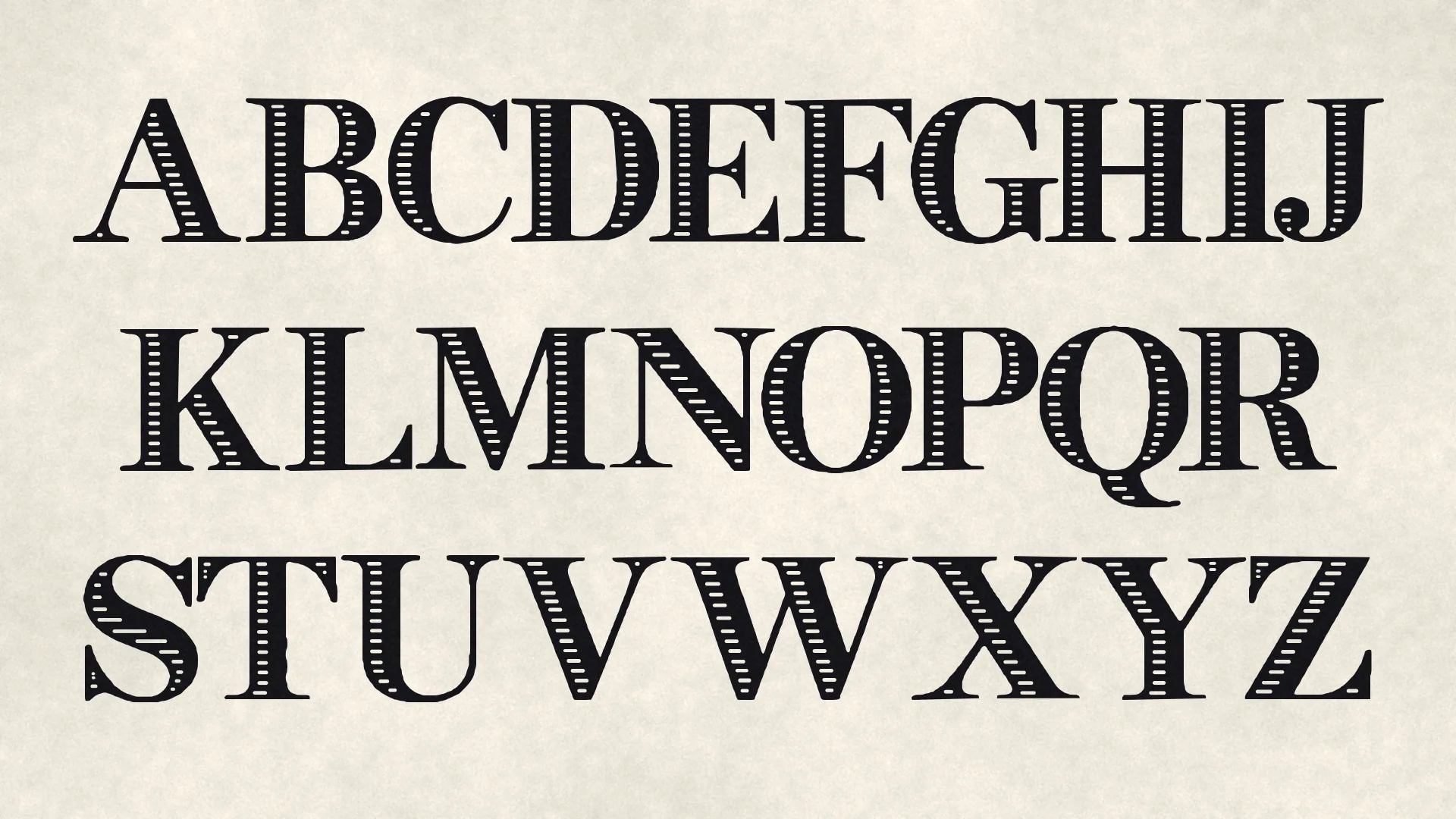 Uppercase A to Z of INK FILIGREE in three rows of black inline serif capitals on laid paper.