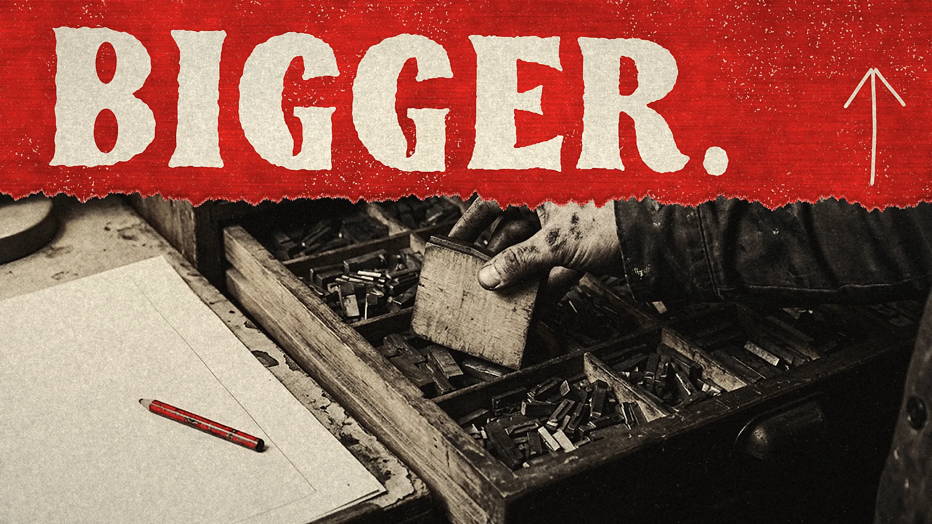 Under the headline BIGGER., a hand lifts a wooden type block from a drawer of metal type beside a red pencil on a blank sheet.