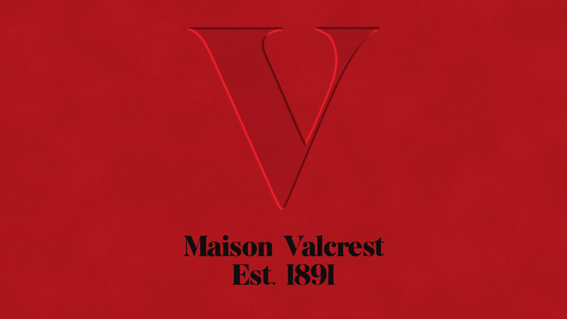 A large V blind-debossed into red stock above the words Maison Valcrest, Est. 1891 in black.